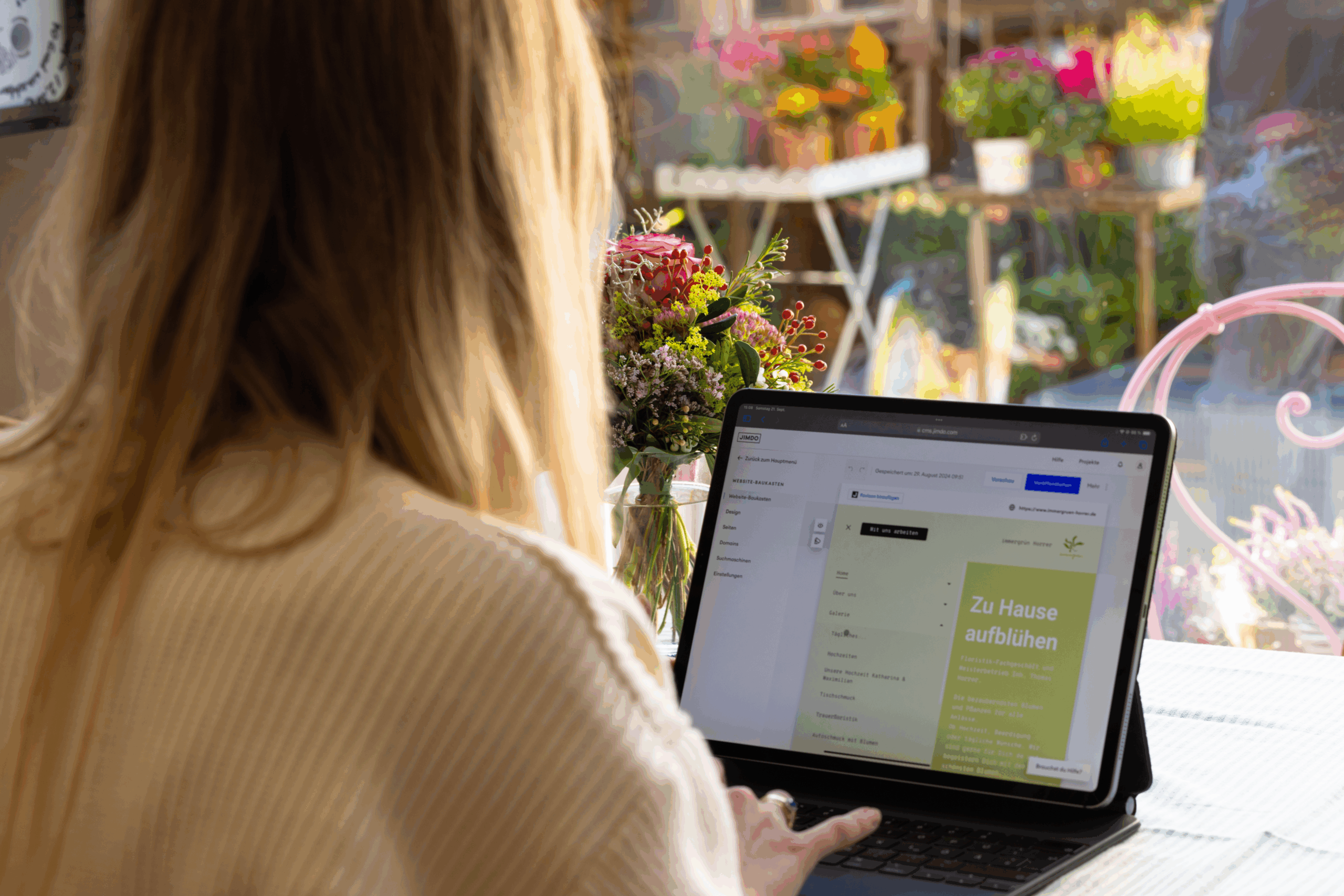 Florist creating her business website with Jimdo on a laptop in a flower shop — simple website building made easy.